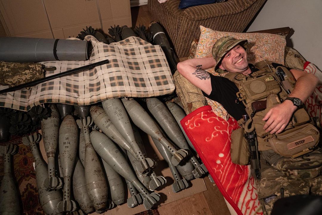 Ukrainian serviceman "Piter" rests on his bed near mortar shells at the front...